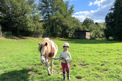 Reitschulkind führt ein Islandpferd von der Koppel im Gestüt Nahetal