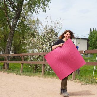 Reitschülerin mit Yogamatte auf dem Weg zur Yogaeinheit auf dem Gestüt Nahetal.